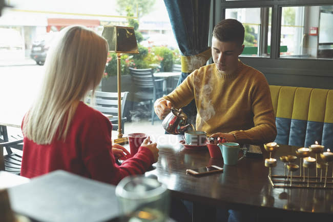 Jeune couple prenant un café dans un café — Photo de stock