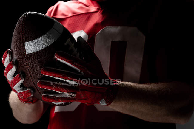 Seção intermediária do jogador de futebol americano segurando bola de rugby — Fotografia de Stock