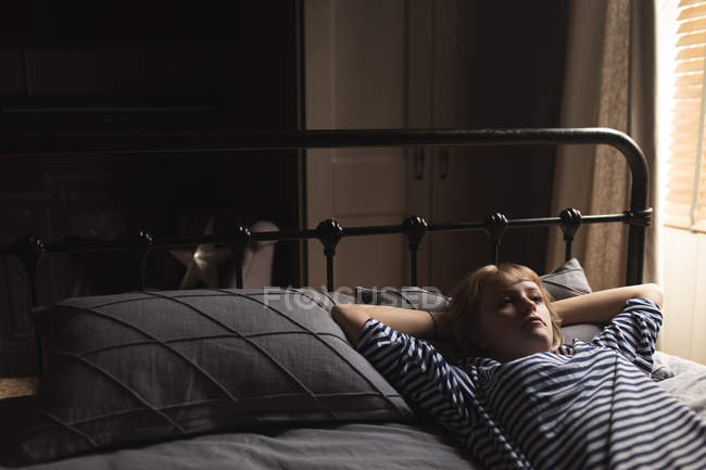 Belle femme se détendre sur le lit dans la chambre à coucher à la maison — Photo de stock