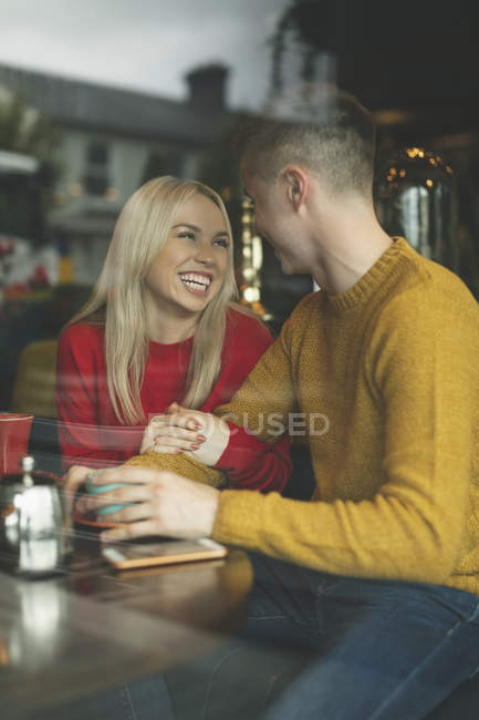 Happy couple interacting with each other in cafeteria — Stock Photo