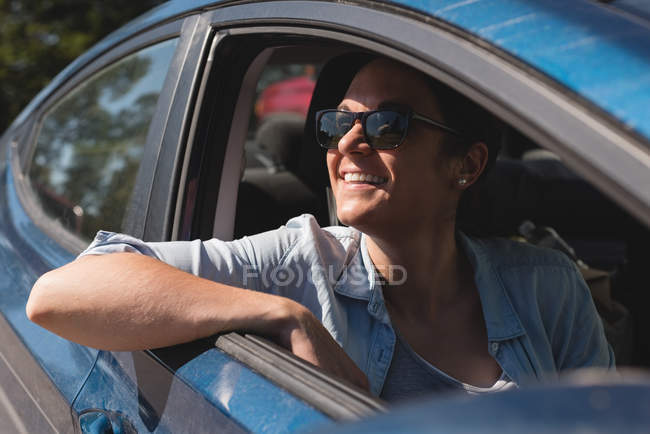Красивая женщина улыбается, сидя в машине — стоковое фото