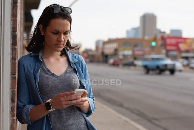 Mulher usando telefone celular na cidade em um dia ensolarado — Fotografia de Stock