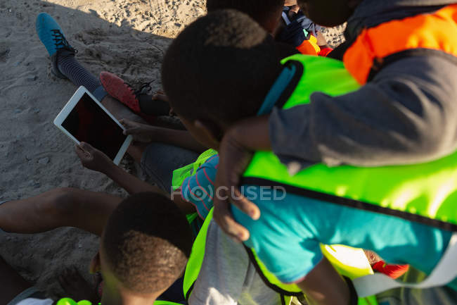 Rear view of kids using digital tablet in the ground — Stock Photo