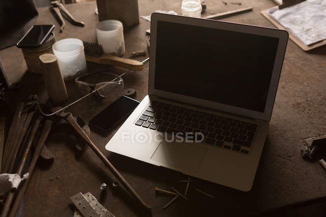 Close-up of laptop in metalsmith factory — Stock Photo