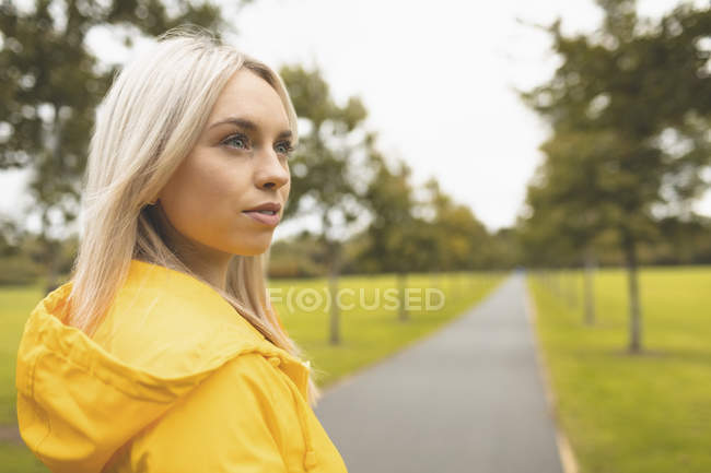 Primo piano della donna che guarda lontano nel parco — Foto stock