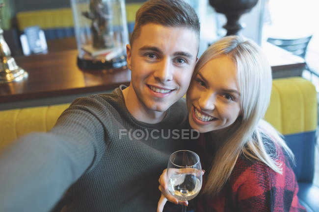 Heureux couple regardant caméra dans le restaurant — Photo de stock