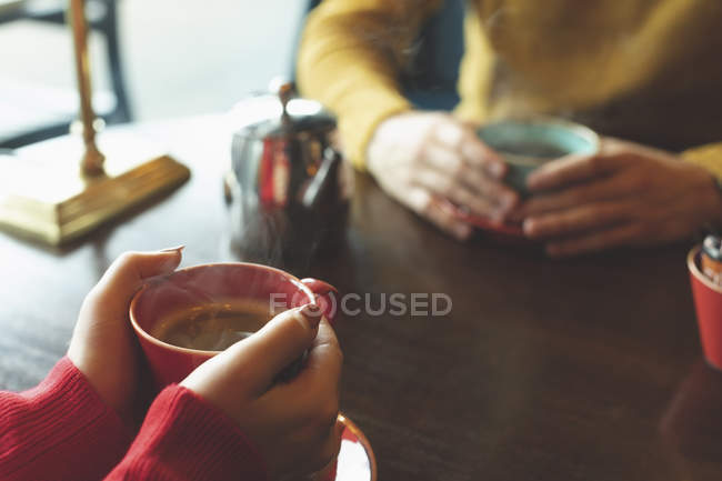Крупный план пары, пьющей кофе в кафе — стоковое фото