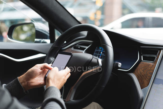 Close-up de homem usando telefone celular em um carro — Fotografia de Stock