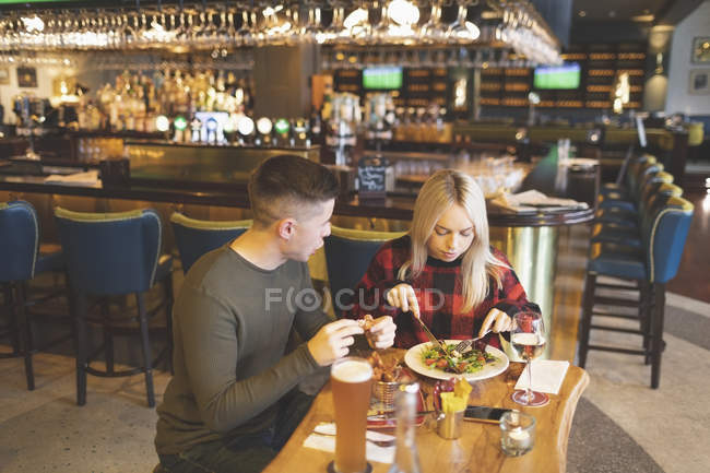 Young couple having food in restaurant — Stock Photo