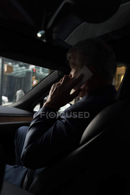 Seitenansicht eines Geschäftsmannes, der im Auto mit dem Handy telefoniert — Stockfoto