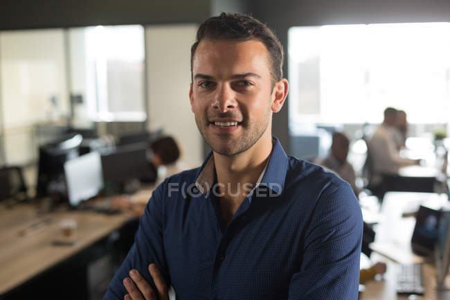 Retrato del ejecutivo masculino mirando a la cámara en la oficina - foto de stock