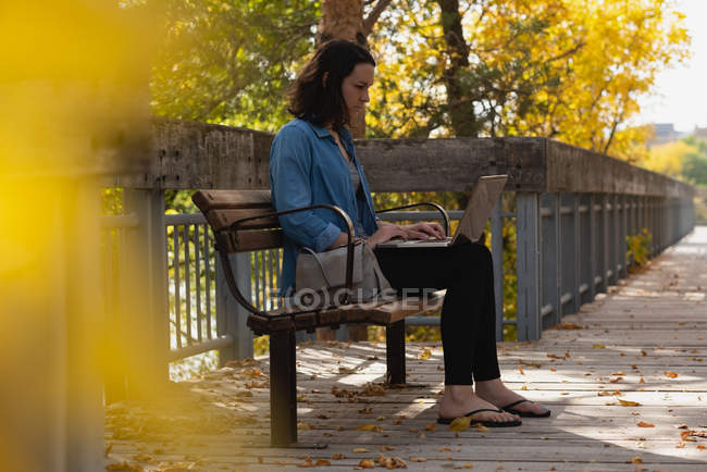 Frau benutzt Laptop an einem sonnigen Tag im Park — Stockfoto