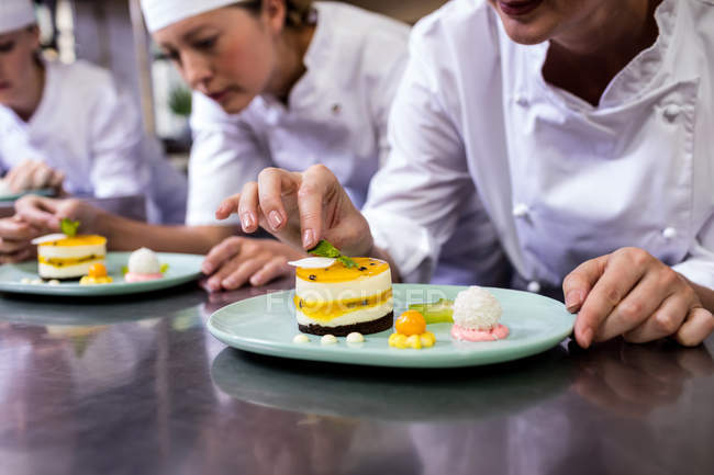 Close-up of chef garnishing dessert on plate — Stock Photo