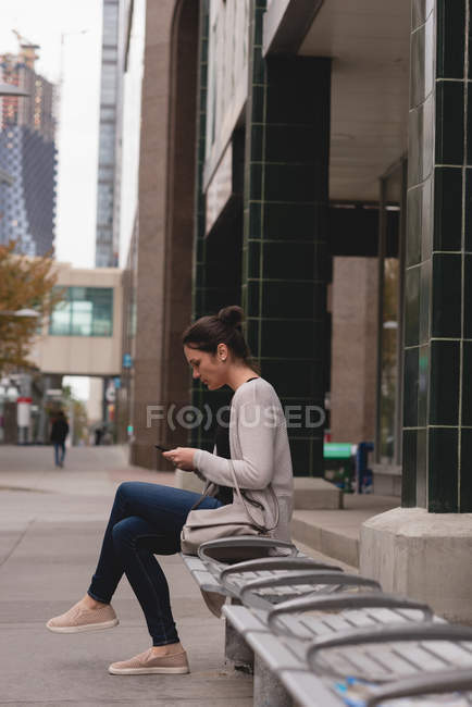 Beautiful woman using mobile phone in the city — Stock Photo