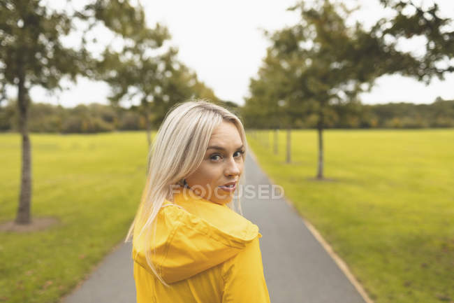 Блондинка смотрит в камеру в парке — стоковое фото