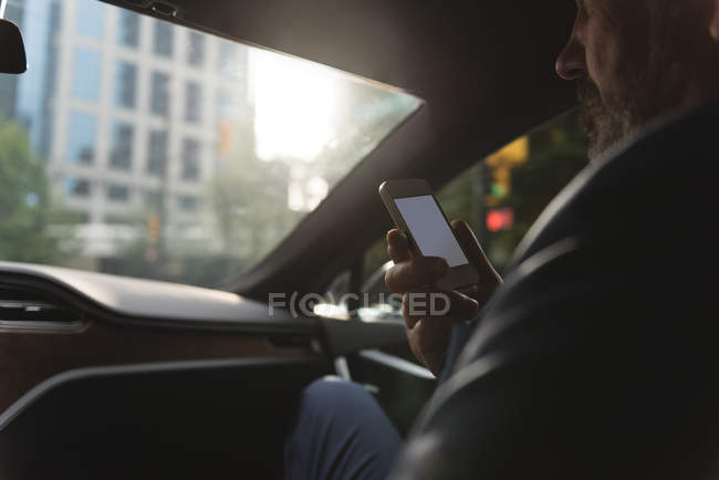 Средняя секция бизнесмена разговаривает по мобильному телефону в машине — стоковое фото