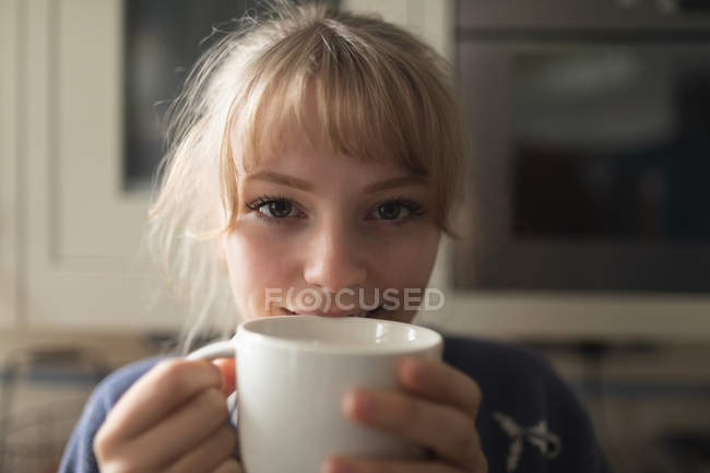 Primer plano de la mujer tomando café en casa - foto de stock