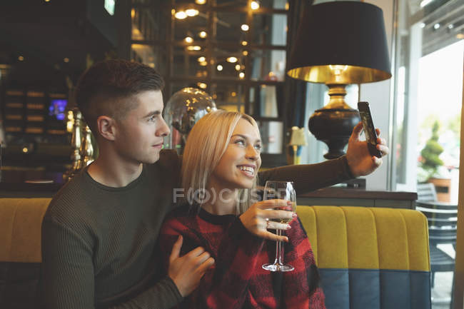 Heureux couple prendre selfie dans restaurant — Photo de stock