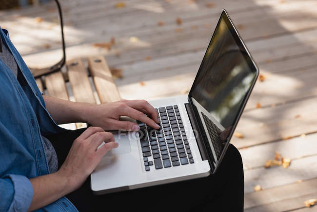 Mid section of woman using laptop in the park — Stock Photo