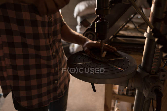 Mid section of female metalsmith using radial drilling machine in factory — Stock Photo