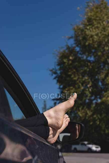 Низкая часть женщины расслабляется с ногами в машине — стоковое фото