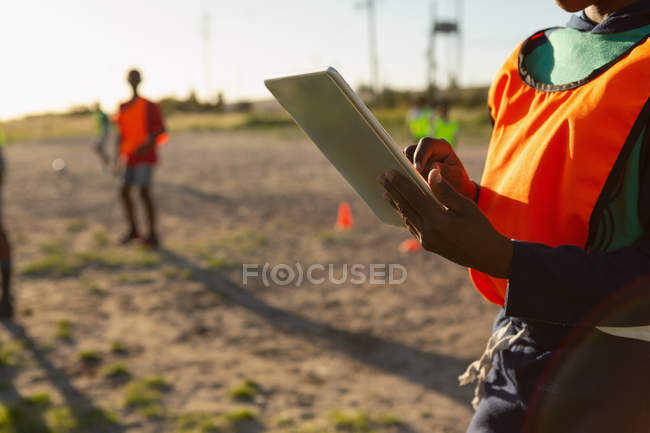 Mid section of kid using digital tablet in the ground — Stock Photo