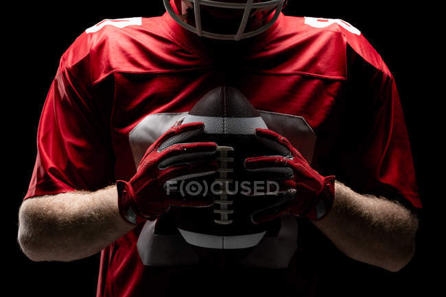 Mid section of American football player holding rugby ball — Stock Photo