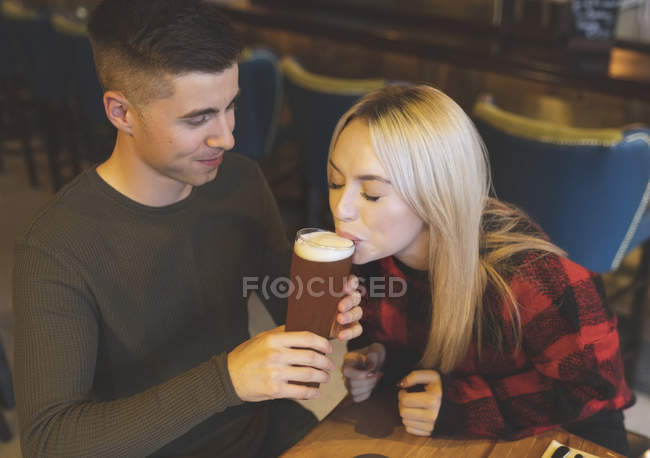 Junges Paar trinkt Bier in Restaurant — Stockfoto