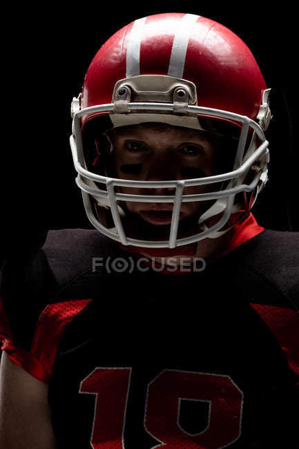 Primo piano del giocatore di football americano in piedi con casco da rugby — Foto stock