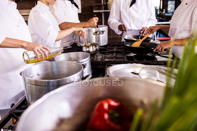 Mid section of chef preparing food in kitchen — Stock Photo