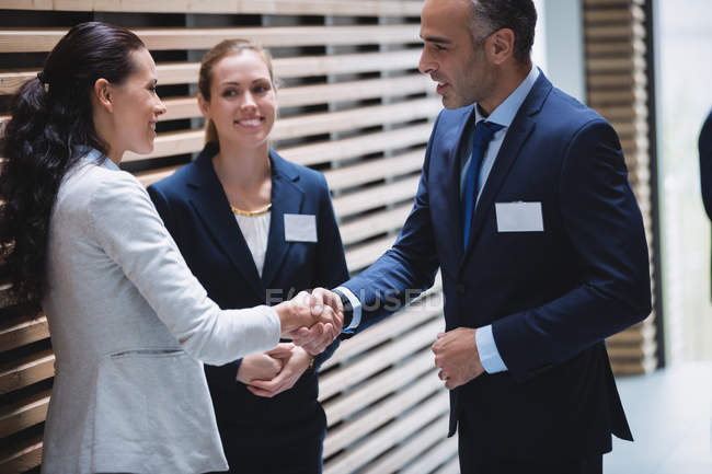 Empresários tendo uma discussão e apertando as mãos no escritório — Fotografia de Stock