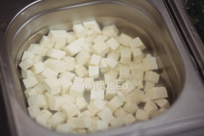 Close-up of chopped paneer in container in restaurant — Stock Photo
