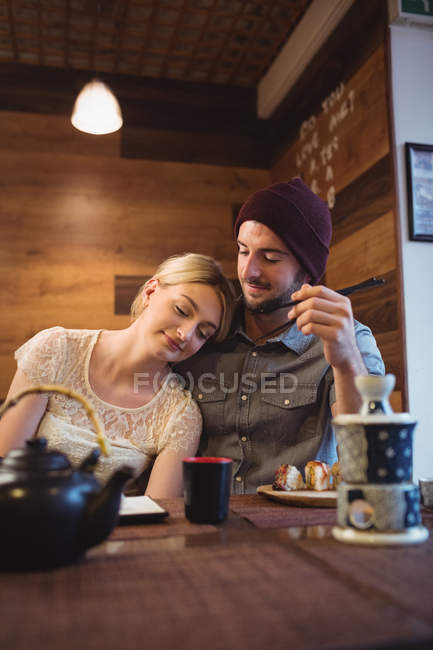 Casal interagindo enquanto come sushi no restaurante — Fotografia de Stock