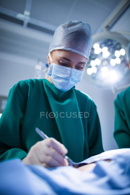 Женщина-хирург, выполняющая операцию в операционном зале больницы — стоковое фото