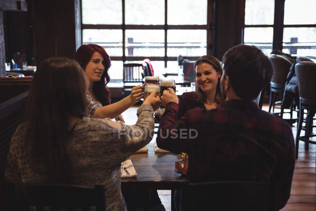 Feliz amigos brindar com copos de cerveja no bar — Fotografia de Stock