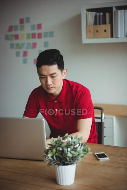 Dirigeant d'entreprise travaillant sur un ordinateur portable au bureau — Photo de stock