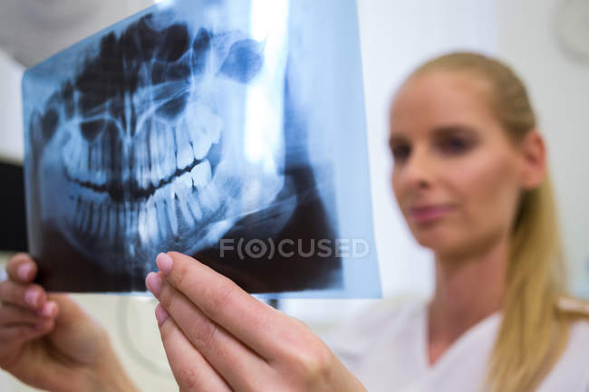 Zahnarzt betrachtet Zahnröntgenplatte in Klinik — Stockfoto