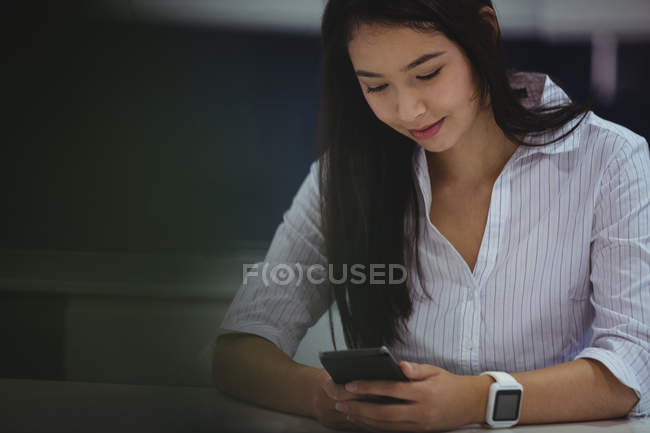 Бізнес-леді використовуючи мобільний телефон в офісі — стокове фото