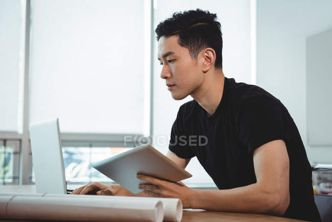 Керівник бізнесу, використовуючи ноутбук і цифровий планшет в офісі — стокове фото