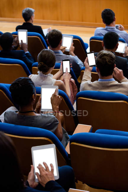 Executivos de empresas que participam de uma reunião de negócios usando tablet digital no centro de conferências — Fotografia de Stock