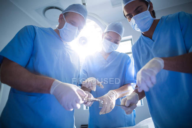 Groupe de chirurgiens opérant en salle d'opération à l'hôpital — Photo de stock