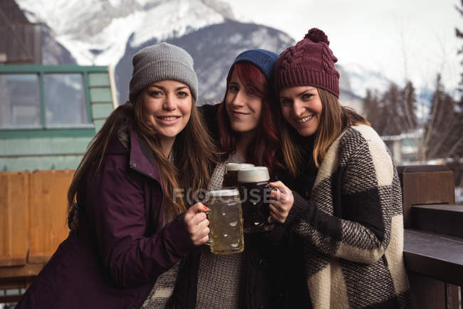 Porträt glücklicher Freunde, die mit Biergläsern in der Bar anstoßen — Stockfoto