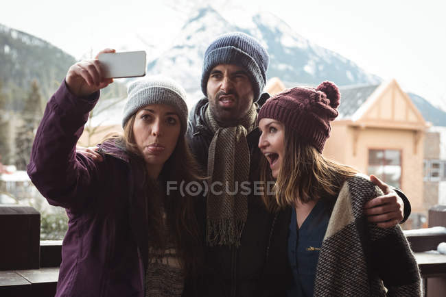 Amigos se divertindo e tirando uma selfie usando telefone celular — Fotografia de Stock