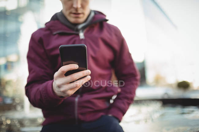 Cropped view of young casual man using mobile phone — Stock Photo