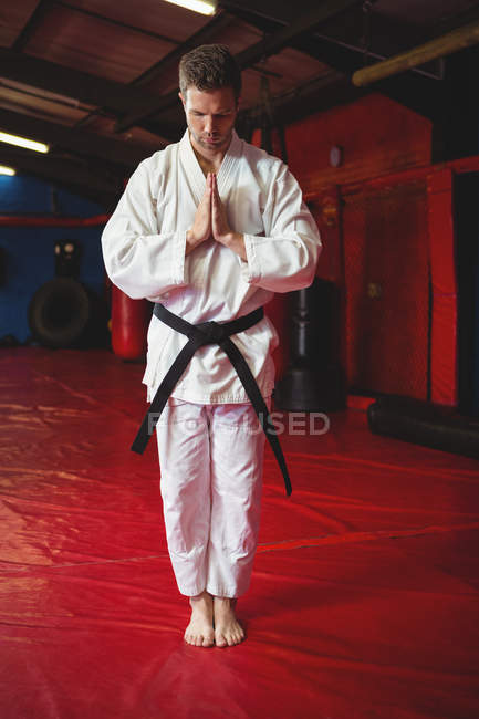 Karate player in prayer pose in fitness studio — Stock Photo