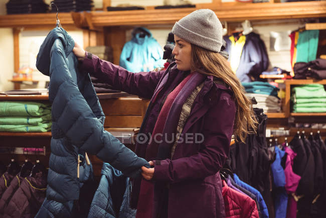 Mujer seleccionando ropa en una tienda de ropa - foto de stock