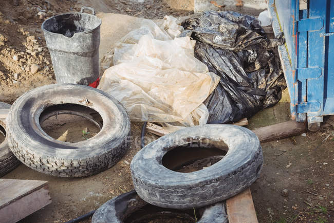 Used tires and plastic sheets at construction site — Stock Photo