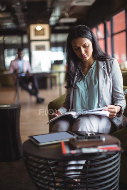 Businesswoman lecture livre dans le bureau — Photo de stock