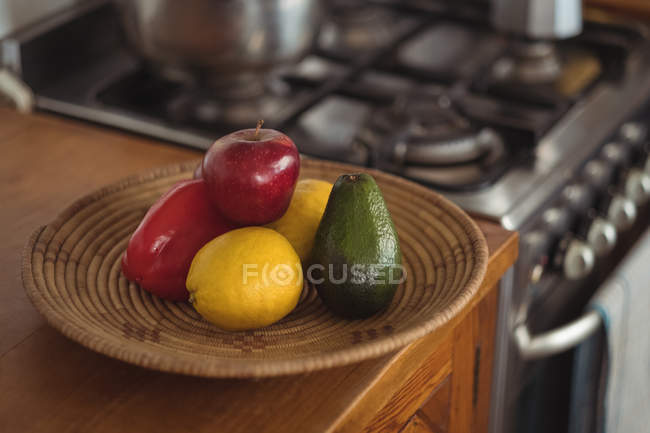 Fruits in bowl at kitchen worktop — Stock Photo
