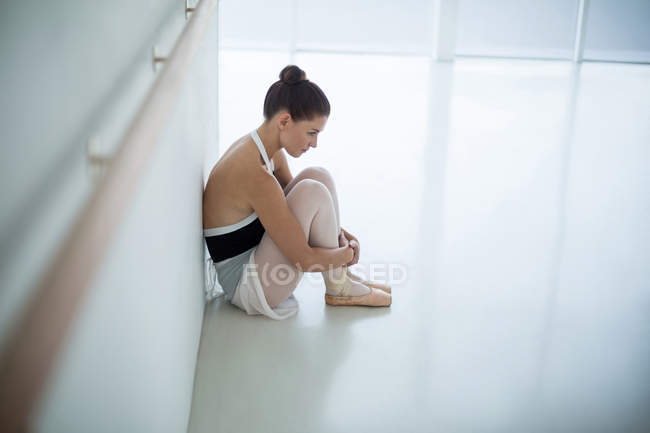 Triste bailarina sentada no chão em estúdio de balé — Fotografia de Stock